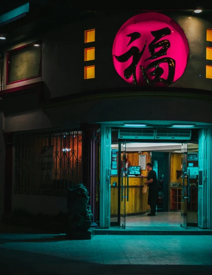 a man stands at an entrance to a dark asian eatery