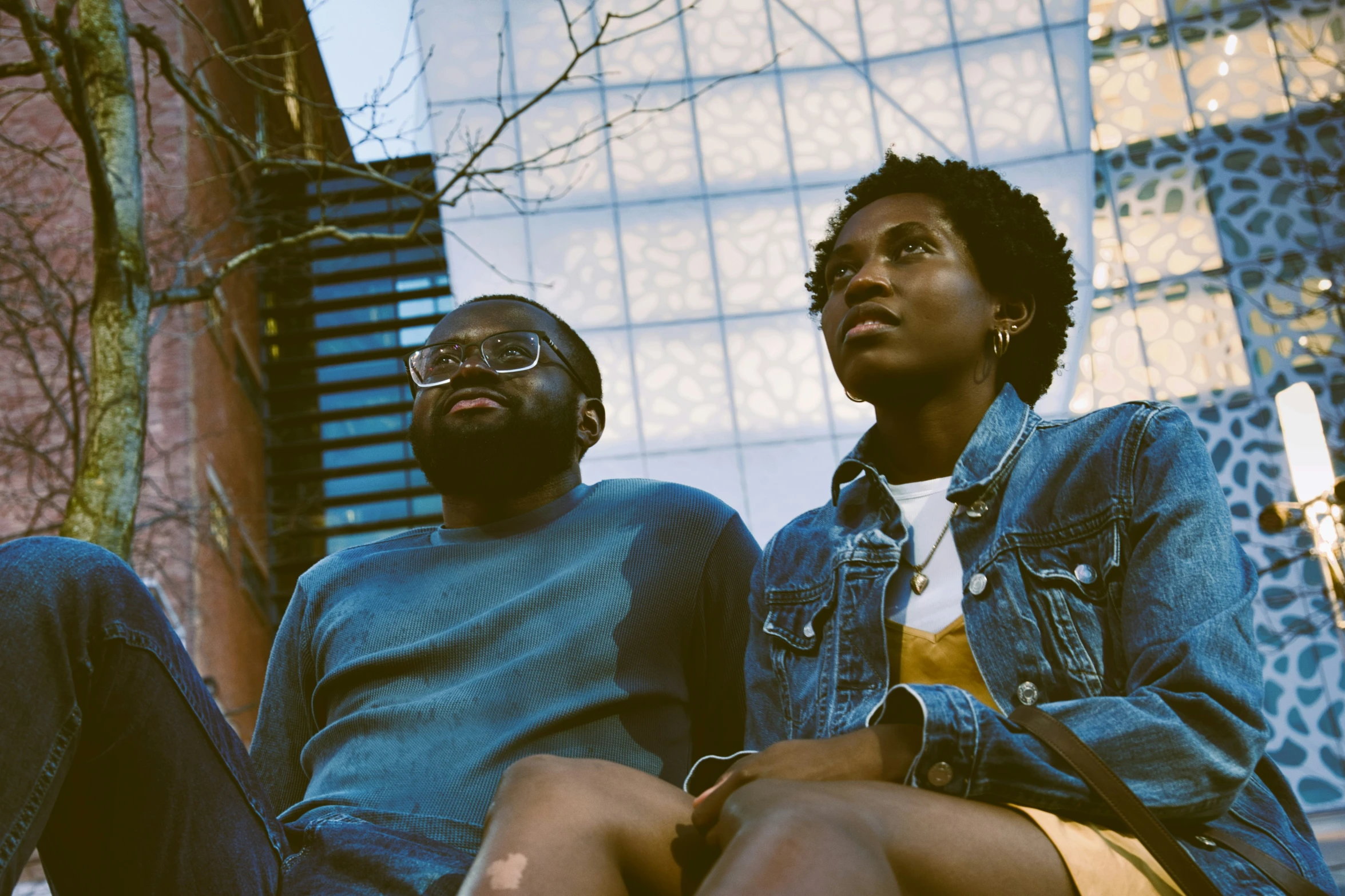 a man sitting next to a woman on a city street