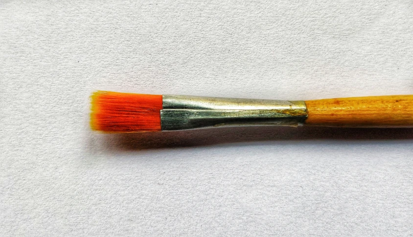 a wooden brush on a white surface