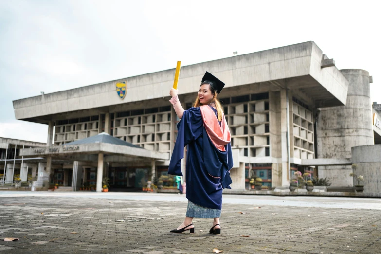 a woman in graduation clothes holding a diploma