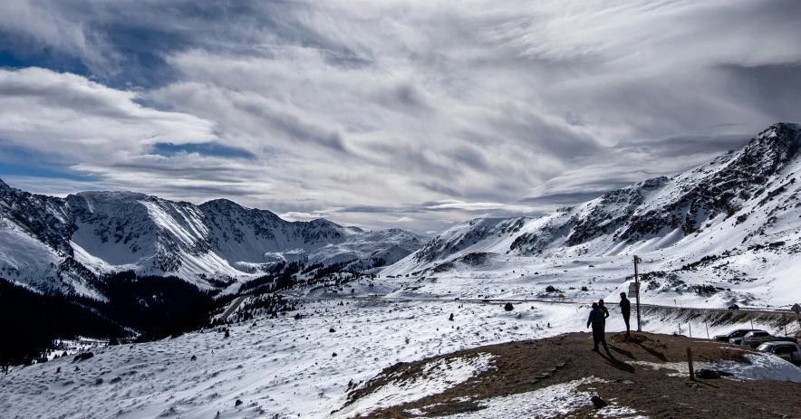 two people in the snow overlooking some mountains