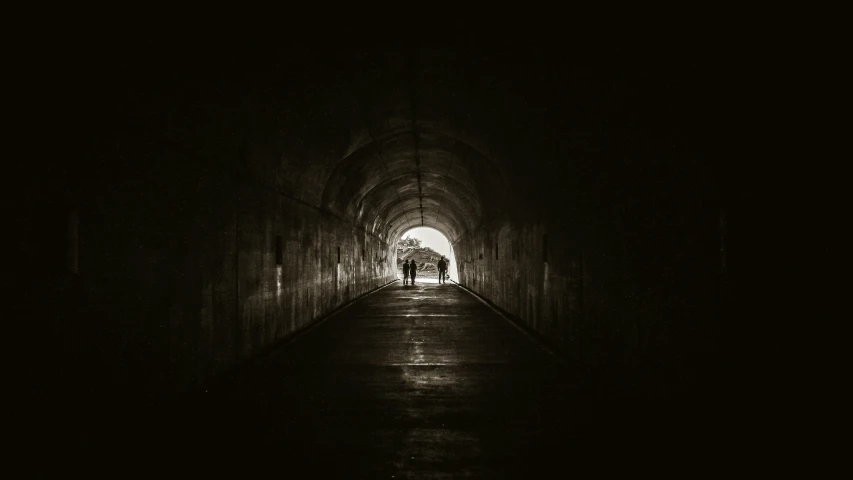 a person that is walking down a tunnel