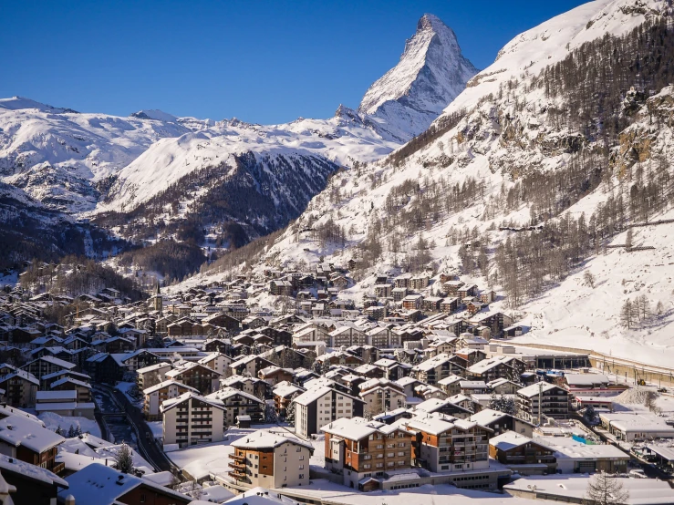 a snowy mountain town is seen from the top of a hill