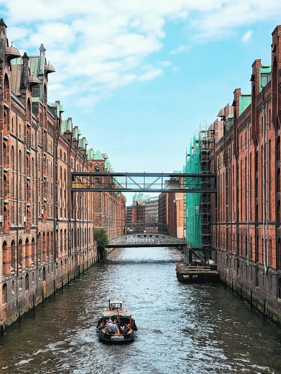 a boat moving down a river past tall buildings