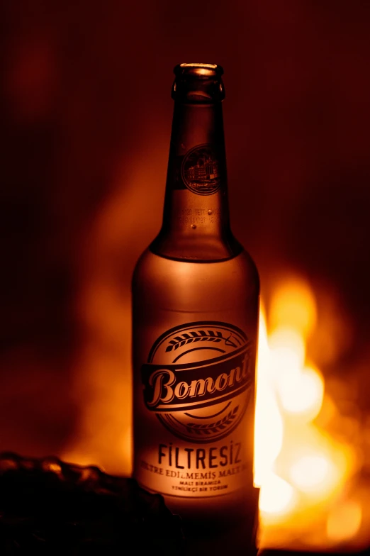 a lighted beer bottle with blurry bo light in the background