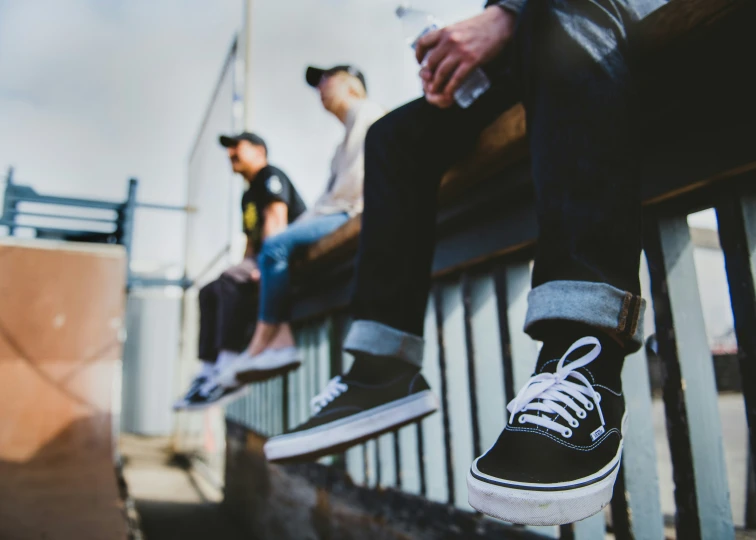 two men are sitting on the benches with shoes