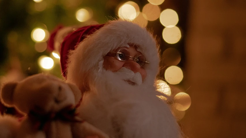 a man with a hat and santa clause holding a teddy bear