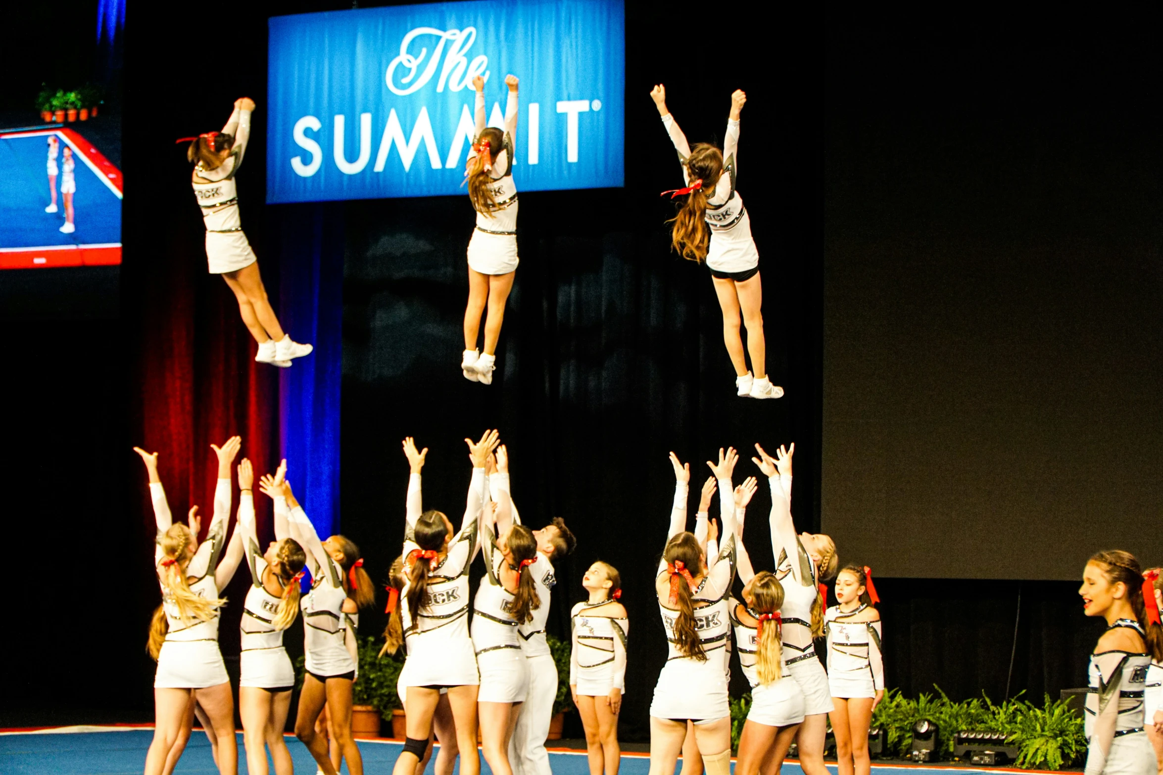 the girls perform a stunt on stage in competition