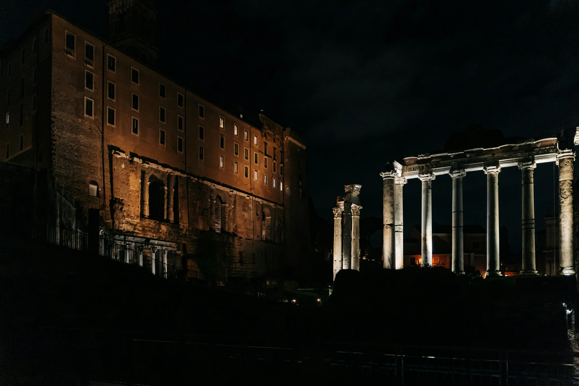 large buildings with many pillars lit up at night