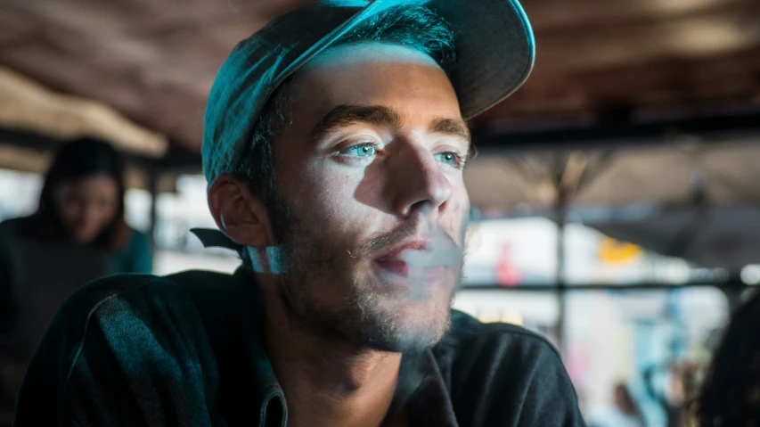 a young man wearing a hat in front of another person