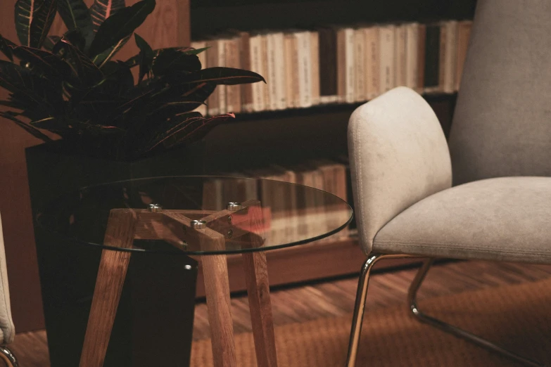 two clear round tables sitting in front of a book shelf