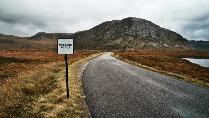 a lone road sign on the side of a hill