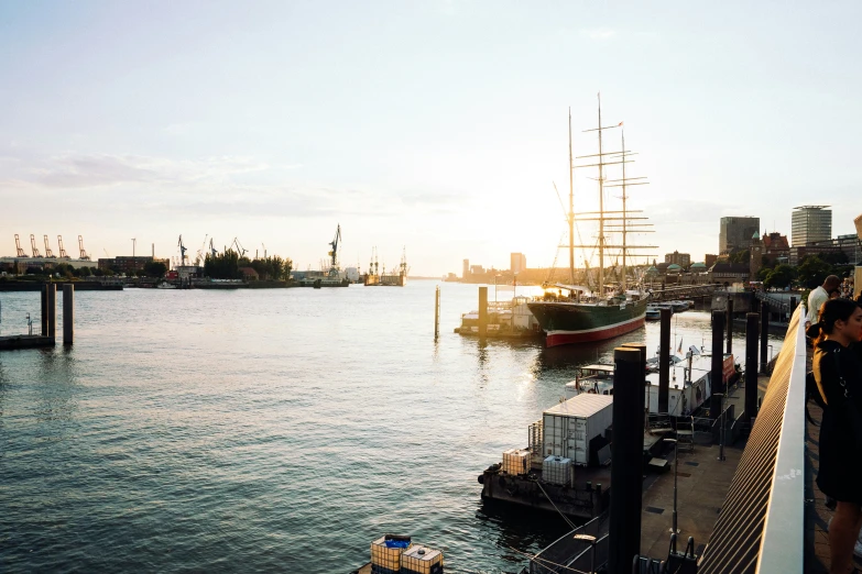 people standing next to a harbor with lots of boats