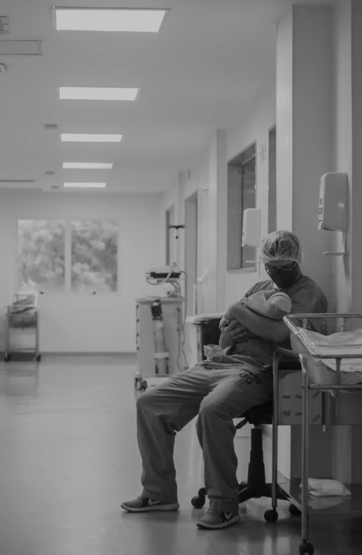 black and white po of elderly people sleeping on hospital chairs