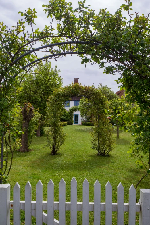 an archway in front of a house over a fence