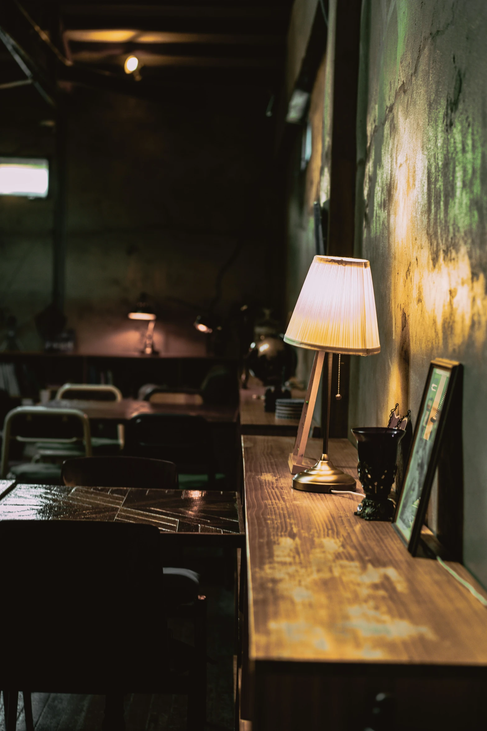 an empty dining room is lit by an antique lamp