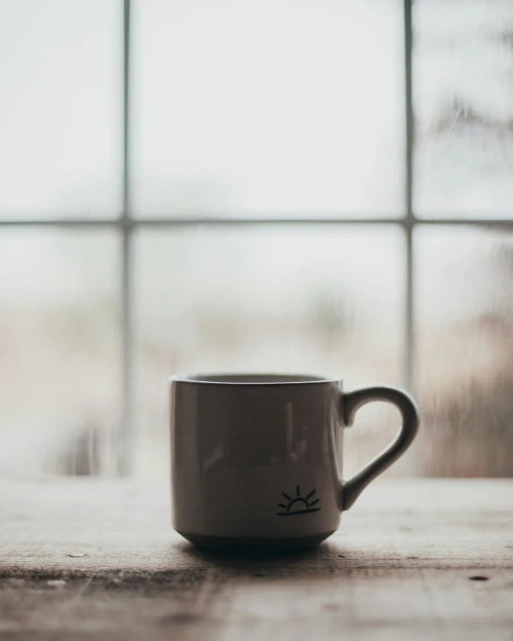 a white coffee mug with the eyes of cats drawn on it