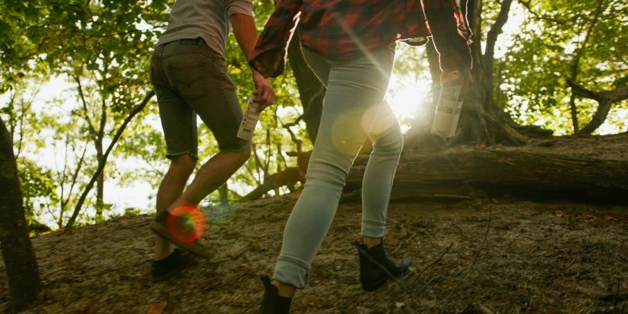 two young people walking down a path in the woods