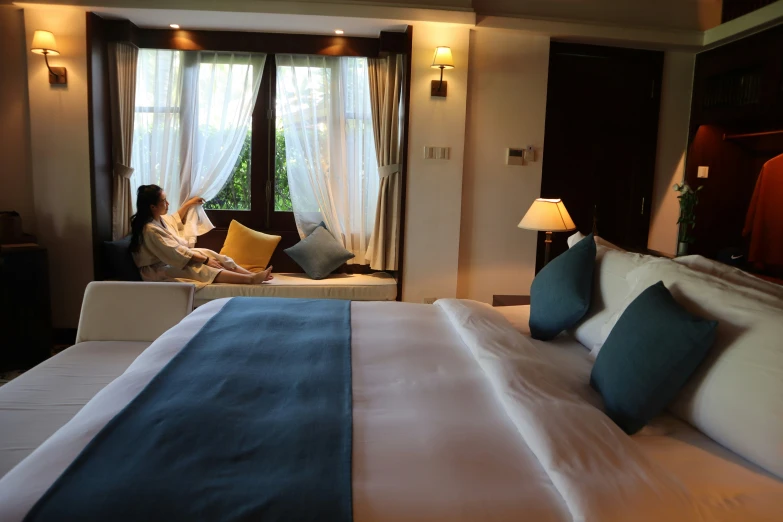 a woman sitting at a bed with two pillows