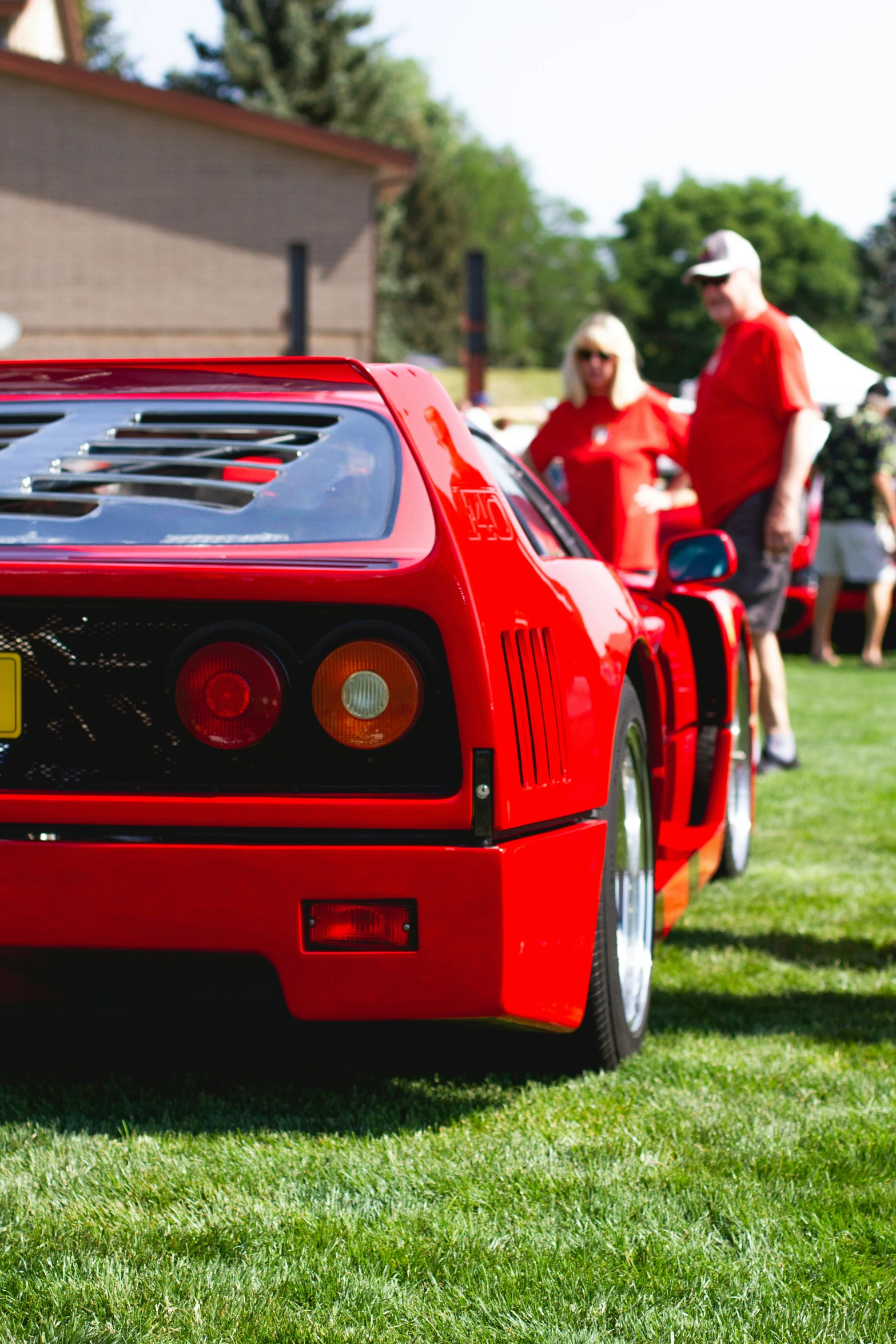 a red race car parked in front of some people