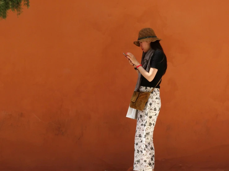 a woman standing in front of an orange wall talking