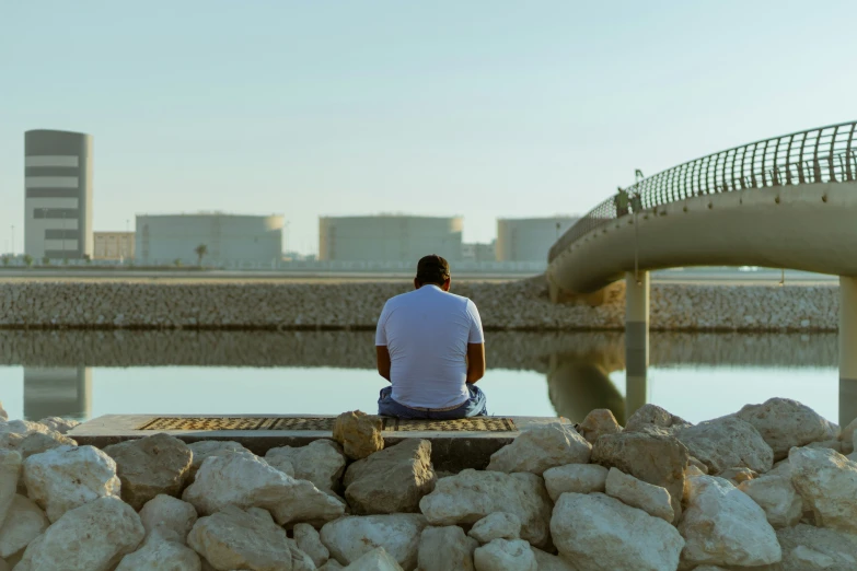 a man sitting on top of a wooden bench