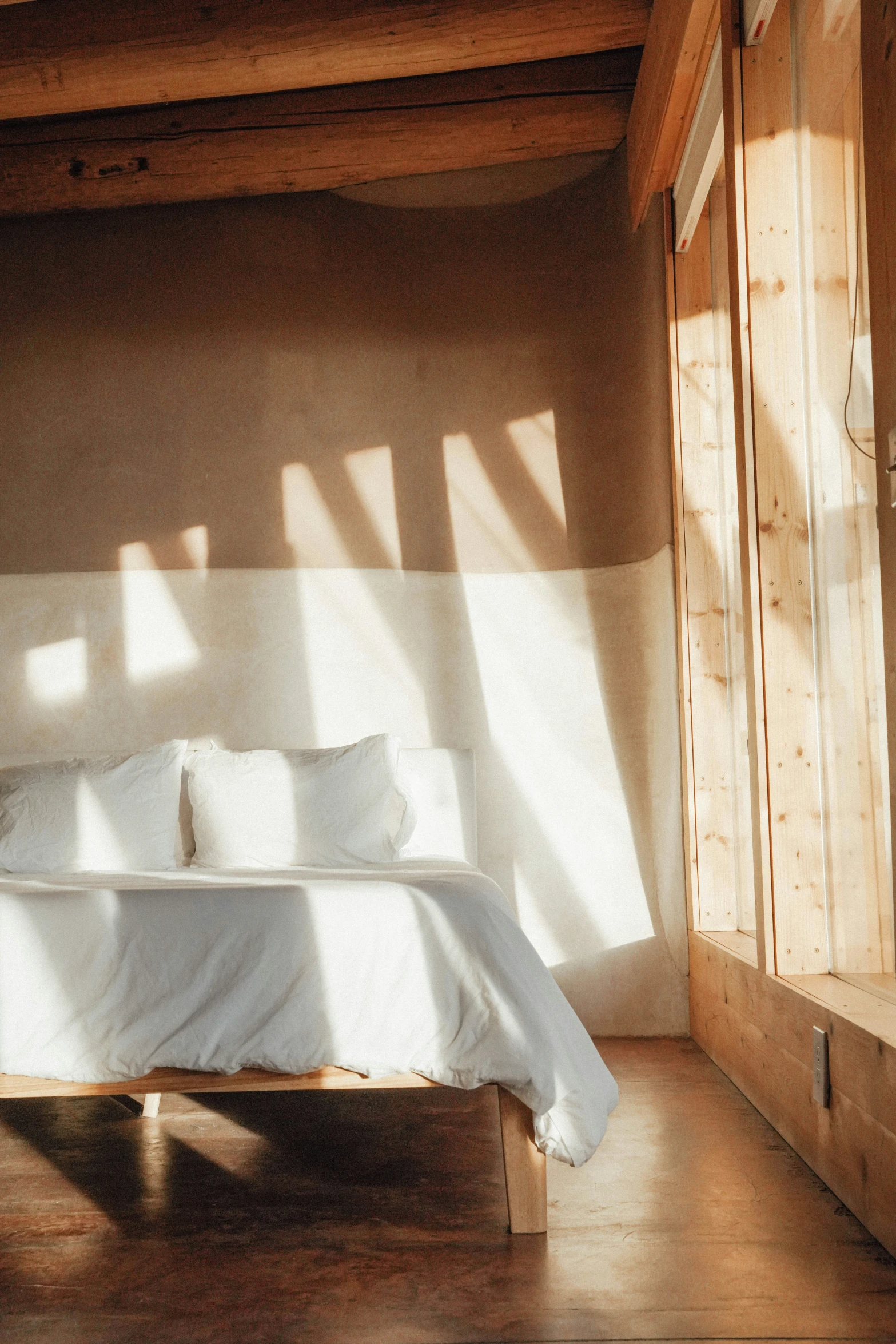 a bed is shown against a wall with several light shining on it