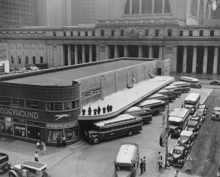 there are many buses parked on the street next to the building