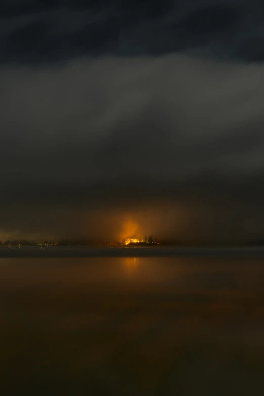 fog rolling over water with lights shining on the water