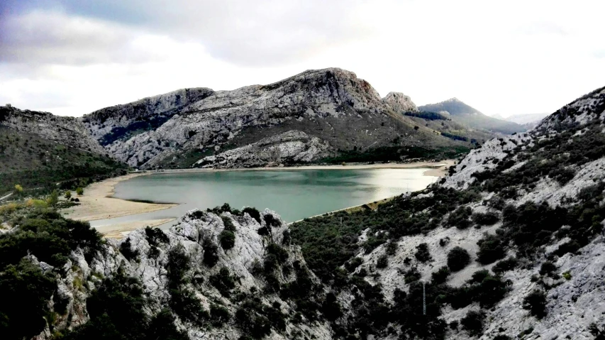 view of a lake on top of a hill, with mountains in the background