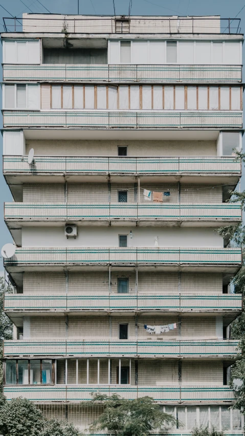 an apartment building with balconies and balconies and a car parked on the street