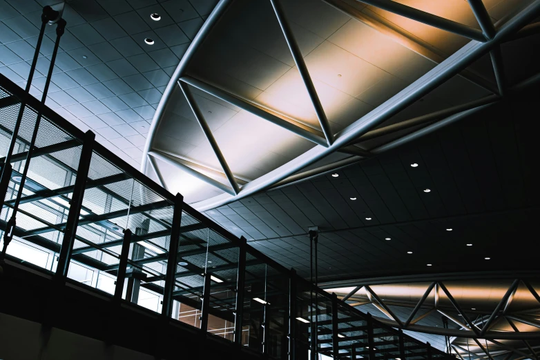 a ceiling that has a bunch of beams and glass covering it