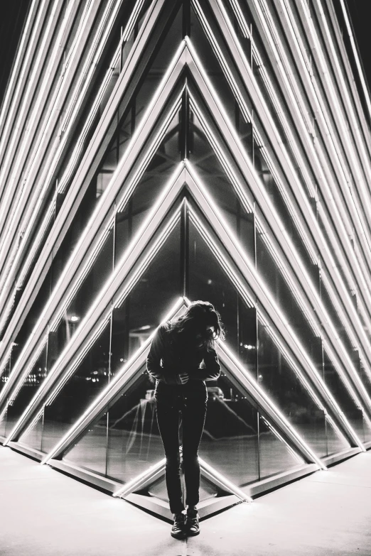 a man stands in front of a very unique light building