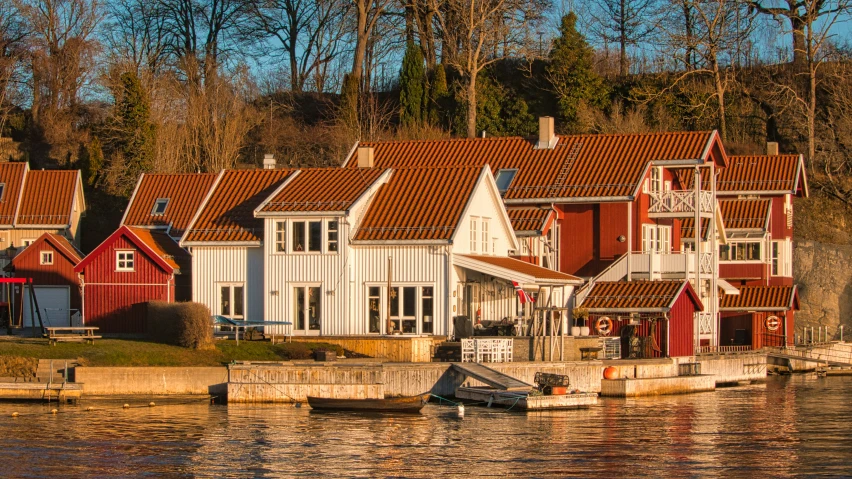 several boats on water next to small red and white houses