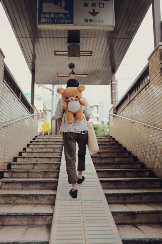 a woman is walking down a ramp with a teddy bear
