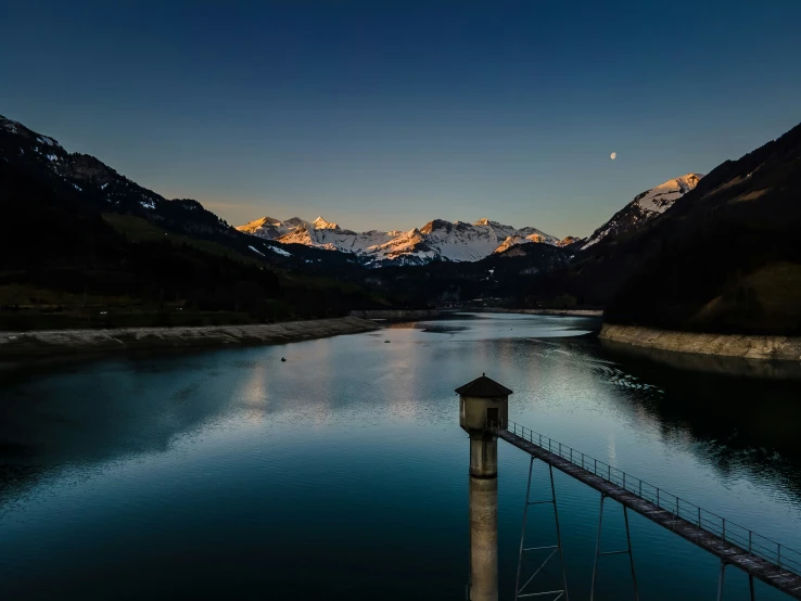 a river at twilight with a view of the mountains