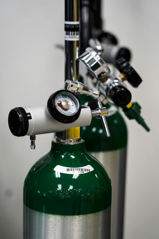 a close up view of the top end of two green propane gas cans