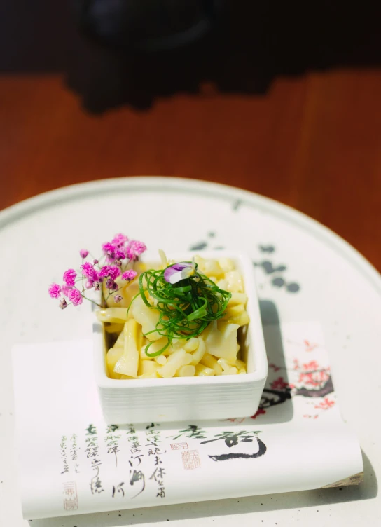 small serving of noodles with a tiny purple flower