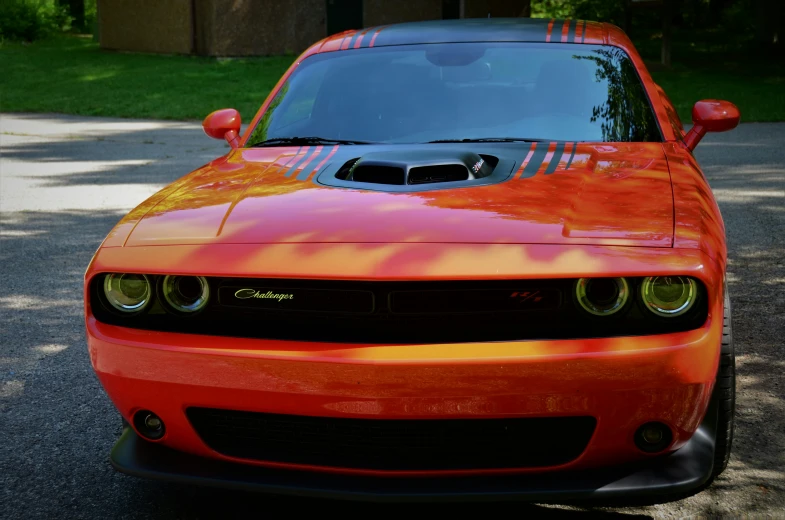 the front end of a red and orange muscle car