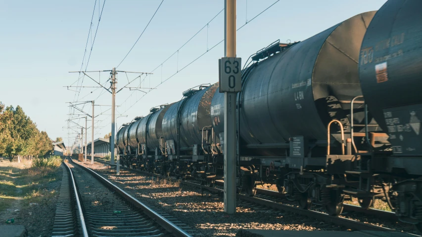 two train engines traveling down tracks near power lines