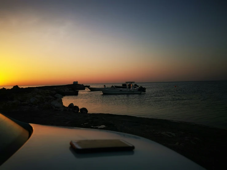 boats are sailing in the water at sunset