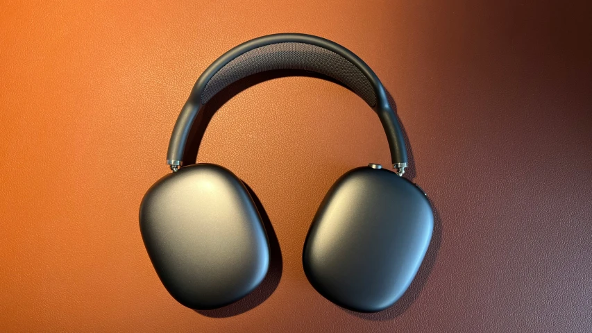 two black headphones on a brown background