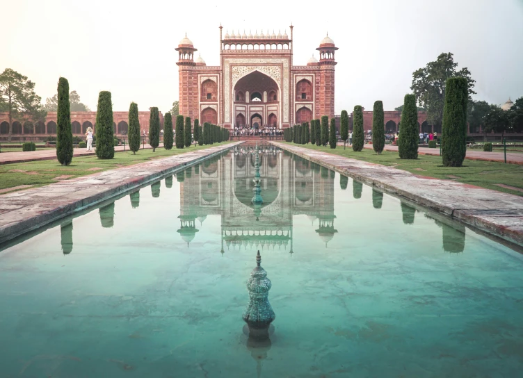 the reflection of an ornamental building in a long pool of water