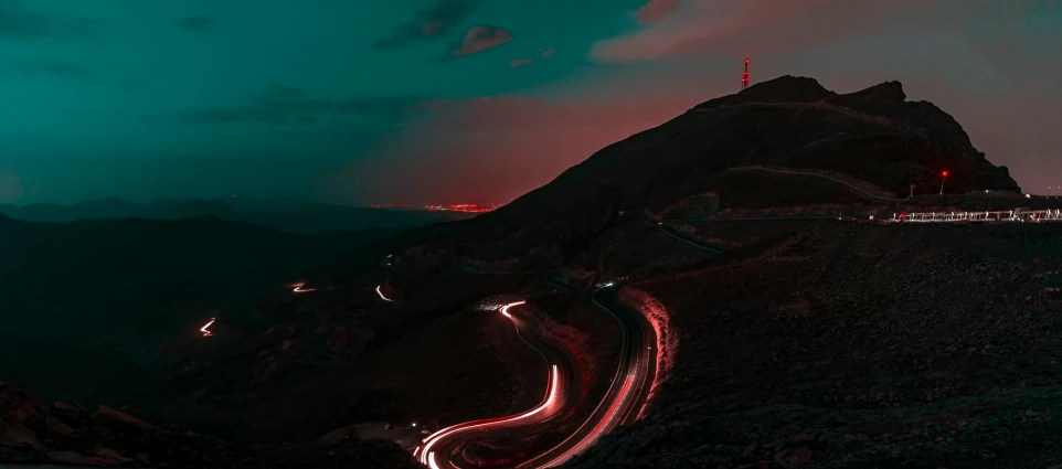 a long line of light streaks in the air above a mountain side