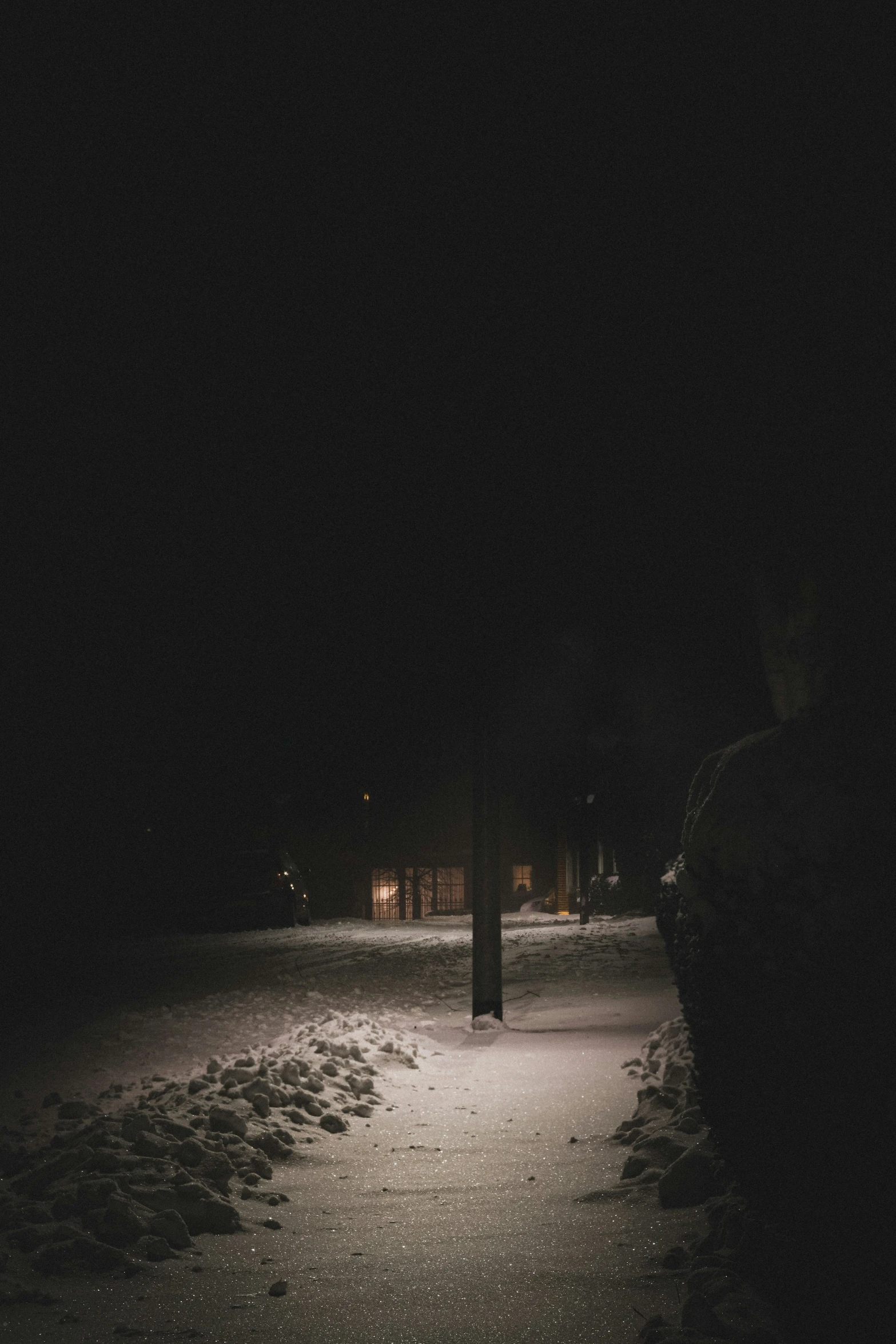 a street light shines brightly at night in the snow