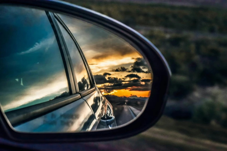 view of a road in the side view mirror of a car