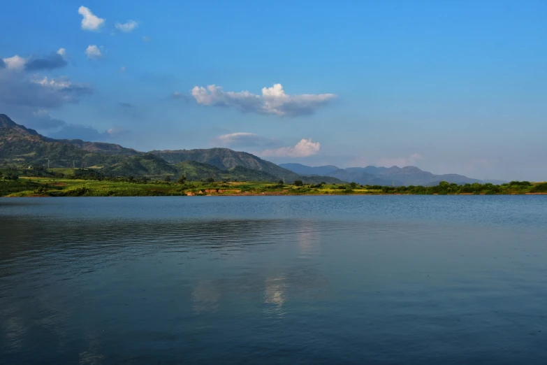 the water is blue and calm under some clouds