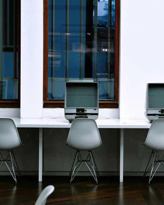 two computers sitting next to each other on white chairs