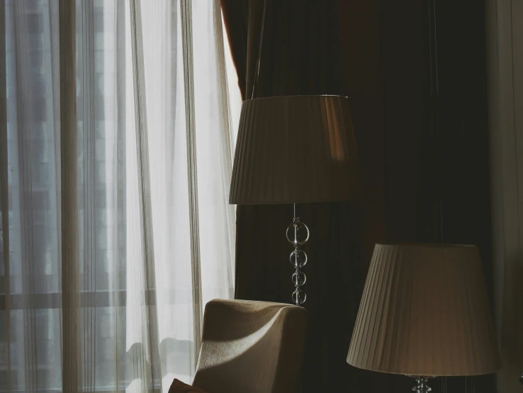 two lamps are in front of a white sheer curtain