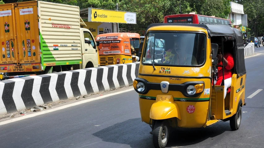 a yellow taxi driving down the road on a sunny day